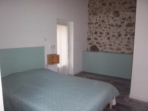 a bedroom with a green bed and a window at Le soleil in Chabanais