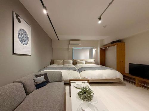 a bedroom with a large bed and a couch at Origaminn 502 by b hotel - 5 mins PeacePark in Hiroshima