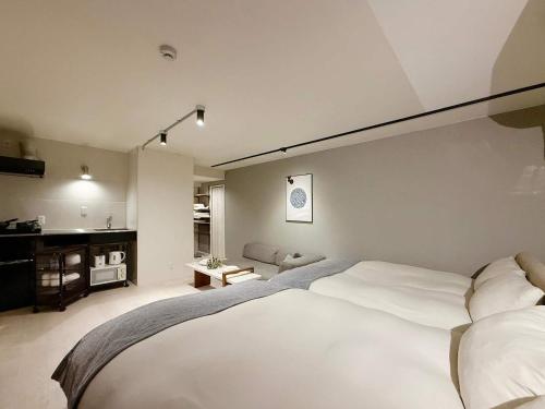 a bedroom with a large white bed in it at Origaminn 502 by b hotel - 5 mins PeacePark in Hiroshima
