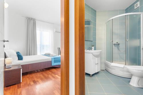 a bathroom with a bed and a bathroom with a shower at LotusApart in Premantura
