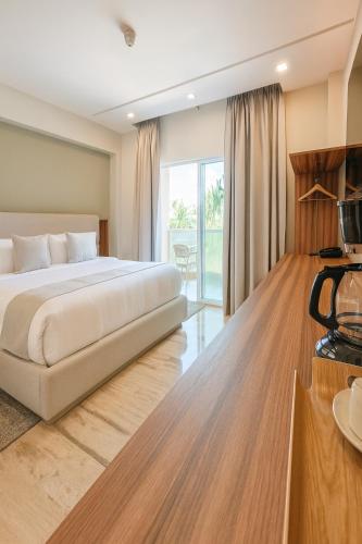 a bedroom with a king sized bed and a balcony at Tibisay Hotel Boutique Morrocoy in Tucacas