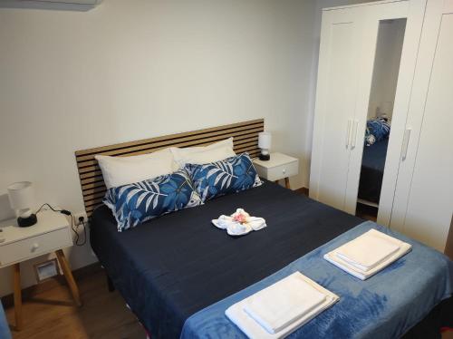 a bedroom with a blue bed with towels on it at Moradia Largo do Pátio in Sertã