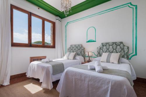 two beds in a room with two windows at Panther Home El Ancla Villa Premium con Piscina Privada in El Puerto de Santa María