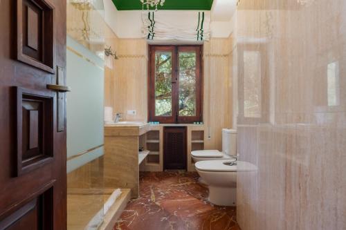 a bathroom with a toilet and a sink and a window at Panther Home El Ancla Villa Premium con Piscina Privada in El Puerto de Santa María