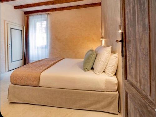 a bedroom with a bed with white sheets and pillows at Corte del Cedro in Provaglio d'Iseo