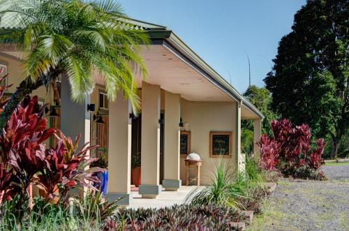 a small house with a palm tree in front of it at Mahana House Country Inn in North Hilo