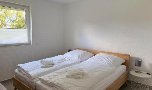 a bed with two towels on top of it at Ferienhaus Wattglück Tossens in Butjadingen