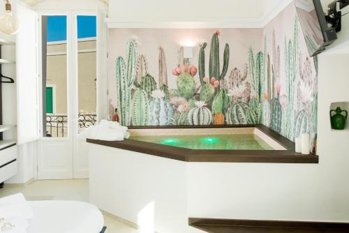 a bathroom with a tub with a mural of cactus at Monsignore Luxury Suite in Monopoli