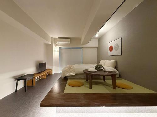 a bedroom with a bed and a table in it at Origaminn 503 by b hotel - 5 mins PeacePark in Hiroshima
