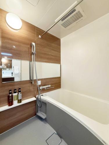 a bathroom with a bath tub and a sink at Origaminn 503 by b hotel - 5 mins PeacePark in Hiroshima