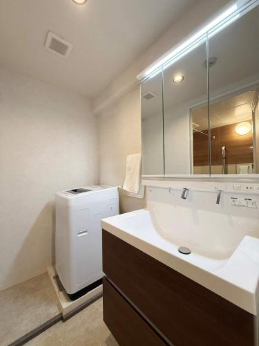 a bathroom with a sink and a washer and dryer at Origaminn 503 by b hotel - 5 mins PeacePark in Hiroshima