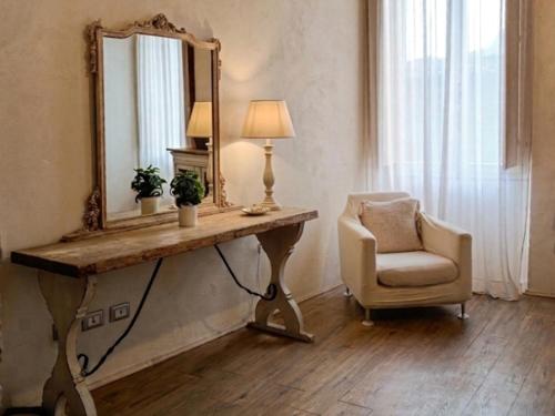 a table with a mirror and a chair in a room at Corte del Cedro in Provaglio d'Iseo