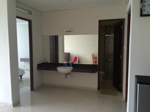 ein Bad mit einem Waschbecken und einem Spiegel in der Unterkunft Roemah Asri Villa - Resor Dago Pakar in Bandung