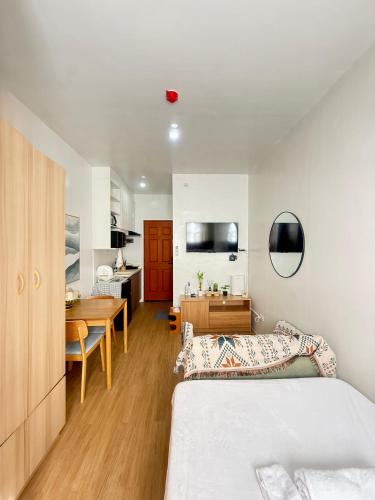 a bedroom with a bed and a desk and a kitchen at E&J Solace Studio Mactan Bayanihan Flats 2 in Maribago