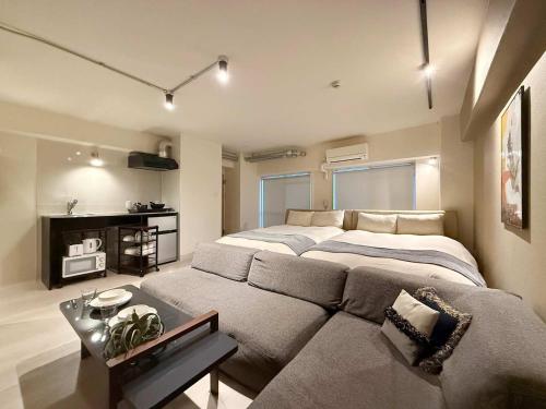 a living room with a large bed and a couch at Origaminn 701 by b hotel - 5 mins PeacePark in Hiroshima