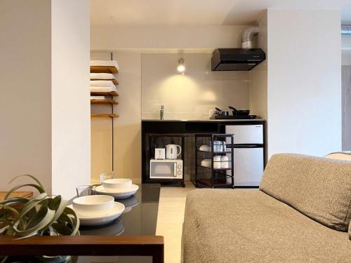 a living room with a couch and a table at Origaminn 701 by b hotel - 5 mins PeacePark in Hiroshima