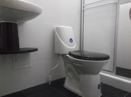 La salle de bains est pourvue de toilettes et d'un lavabo. dans l'établissement Hotel Monarca Putumayo, à Orito