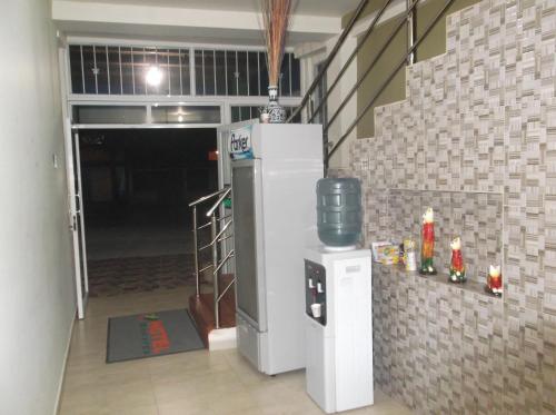 a room with a white refrigerator and a staircase at Hotel Monarca Putumayo in Orito