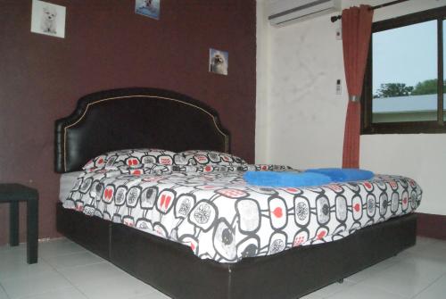 a bedroom with a bed with a black and white comforter at Pineapple Guesthouse in Karon Beach