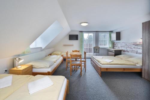a dorm room with four beds and a table at Pension Katty in Špindlerův Mlýn