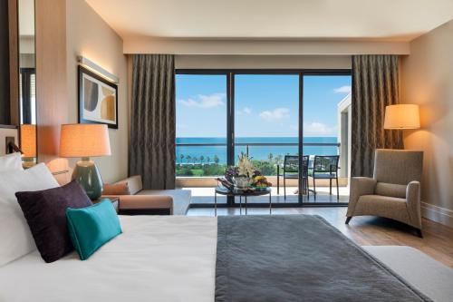 a hotel room with a bed and a view of the ocean at Susesi Luxury Resort in Belek
