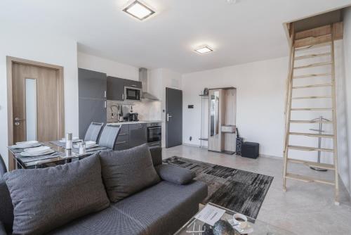 a living room with a couch and a kitchen at Čajkovskij Apartments in Brno