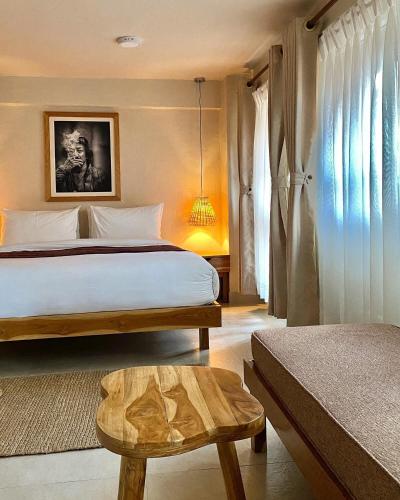a bedroom with a bed and a table and window at Apartments by Karma Artful Retreat in Patan Durbar Square in Pātan