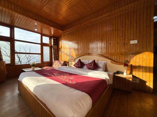 a bedroom with a large bed in a wooden room at New Amar Palace Shimla with Mountain View in Shimla