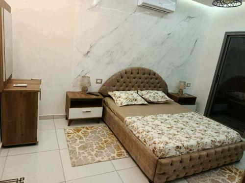 a bedroom with a bed with a tufted headboard at Villa RAZAN in Midoun