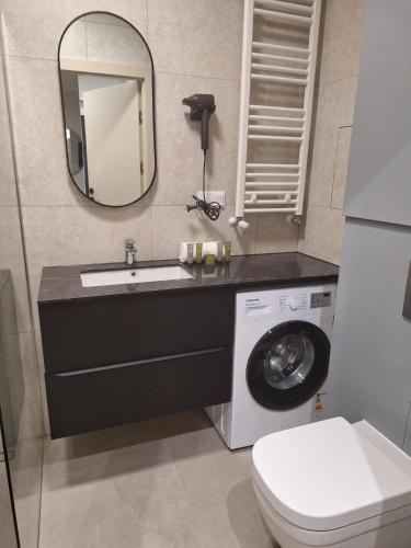 a bathroom with a sink and a washing machine at Forest Międzyzdroje in Międzyzdroje