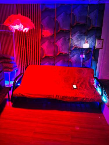 a bedroom with a red bed with lights on it at Jace Haven Deluxe in Binangonan