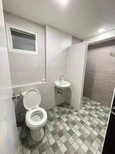 a bathroom with a toilet and a sink at Baan Thanaluk 1 Pattaya in Pattaya