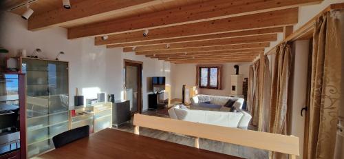 a living room with wooden ceilings and a living room with white furniture at Chalet Wildi Horu OG in Niedergesteln