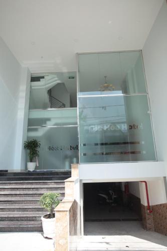 a glass facade of a building with stairs and plants at Gia Hoa Airport Hotel in Ho Chi Minh City