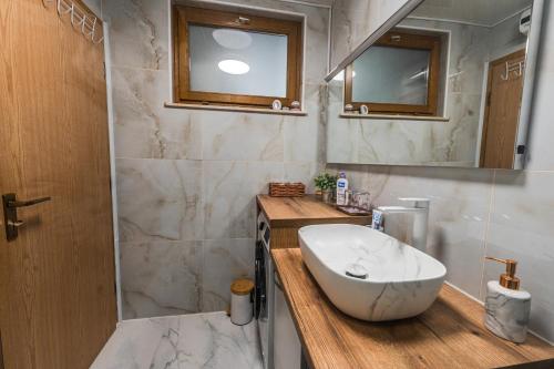 a bathroom with a white sink and a mirror at Apartman Draga in Varaždin