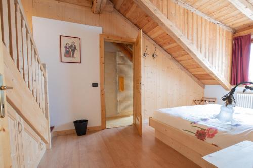 a bedroom with a bed in a wooden house at Residenza Domino in Selva di Cadore