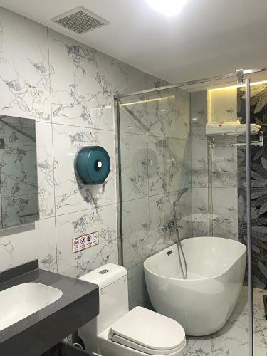 a bathroom with a toilet and a sink and a tub at Khách Sạn Phượng Vĩ in Cà Mau
