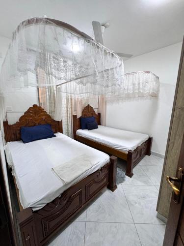 two twin beds in a bedroom with a mosquito net at Two bedroom, Nyali rd in Mombasa