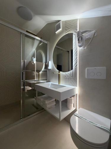 a bathroom with a toilet and a sink and a mirror at Pensiunea Brici in Cluj-Napoca