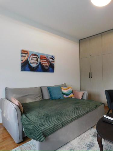a bedroom with a couch and a painting of boats at Cetinjska apartment in Belgrade