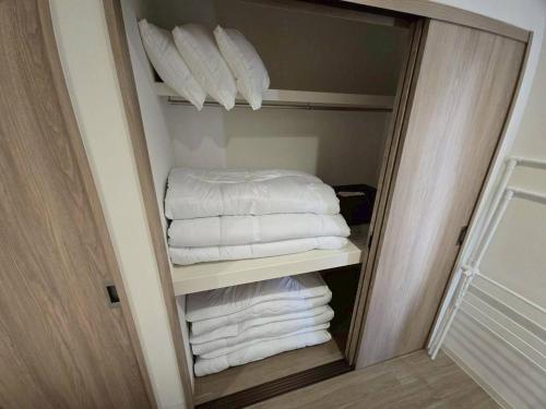 a closet with a stack of towels and pillows at Tiz円居 in Minamiawaji