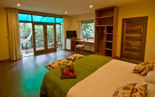 een slaapkamer met een bed en een badkamer met een wastafel bij Tierra Guaraní Lodge in Puerto Iguazú