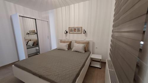 a small bedroom with a bed and a mirror at Apartments Barbic in Medulin