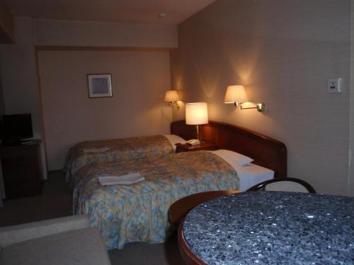 A bed or beds in a room at Hotel Crown Hills Okaya