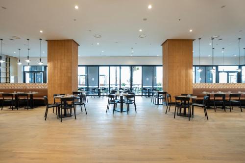 a dining room with tables and chairs and windows at Hotel101 - Madrid in Madrid