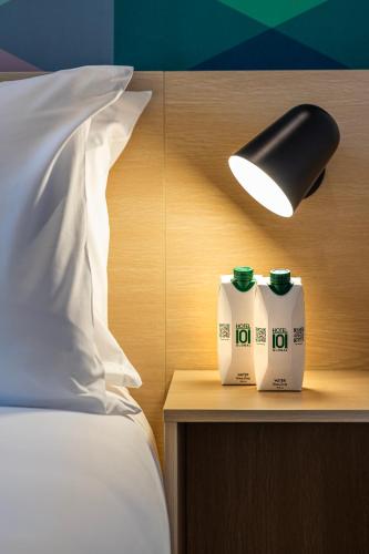 a bedroom with a bed and a lamp and two milk containers at Hotel101 - Madrid in Madrid