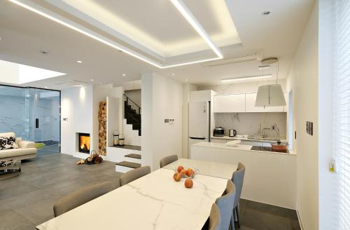 a kitchen and living room with a white table and chairs at Be,Bridge Pool Villa Resort in Yeongwol