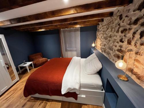 a bedroom with a bed and a stone wall at Villa Gloria in Tourtour