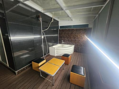 a bathroom with a tub and a table and chairs at Zenith Hotel in Guri