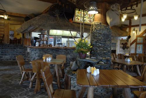 een restaurant met houten tafels en een stenen muur bij Karczma We Młynie in Tuszyn